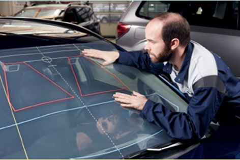 En utbildad tekniker kalibrerar en nyinstallerad vindruta med hjälp av avancerad utrustning – ett viktigt steg för att säkerställa korrekt funktion i förarassistanssystem som EyeSight