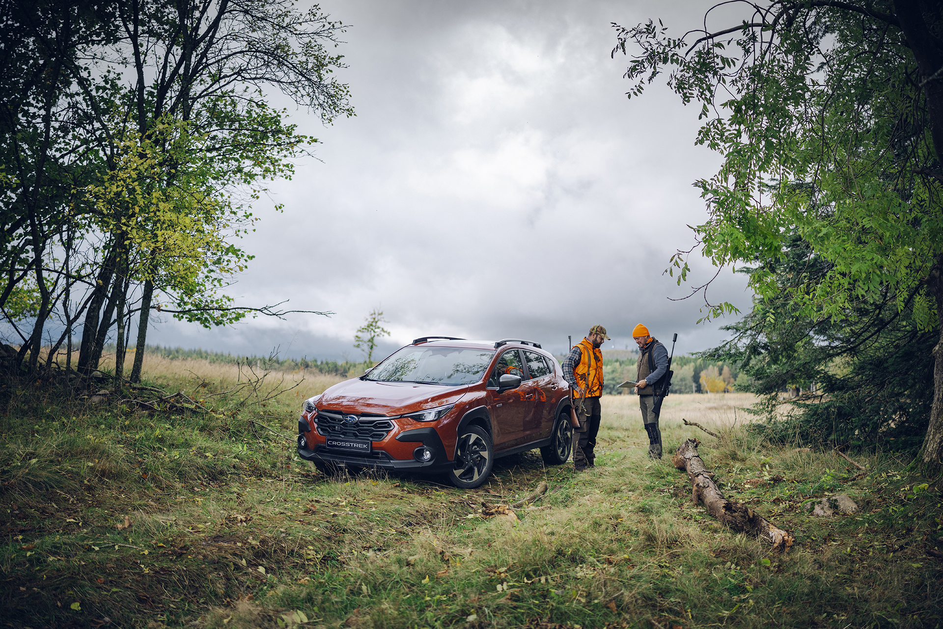 Subaru Crosstrek i skogen med jägare – perfekt för jakt, fiske och äventyr, tack vare bilens smidiga storlek, fyrhjulsdrift och markfrigång.