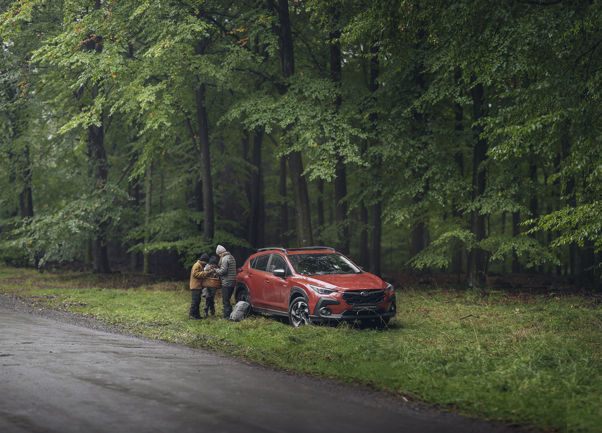 Subaru Crosstrek i skogen med familj och svampkorg – en mångsidig bil för friluftsliv, vardagsäventyr och trygga turer ut i naturen.