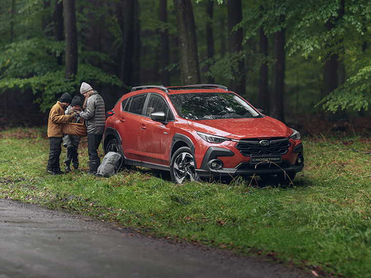 Subaru Crosstrek i skogen med familj och svampkorg – perfekt för aktiva dagar i naturen tack vare bilens fyrhjulsdrift, markfrigång och smidiga format.