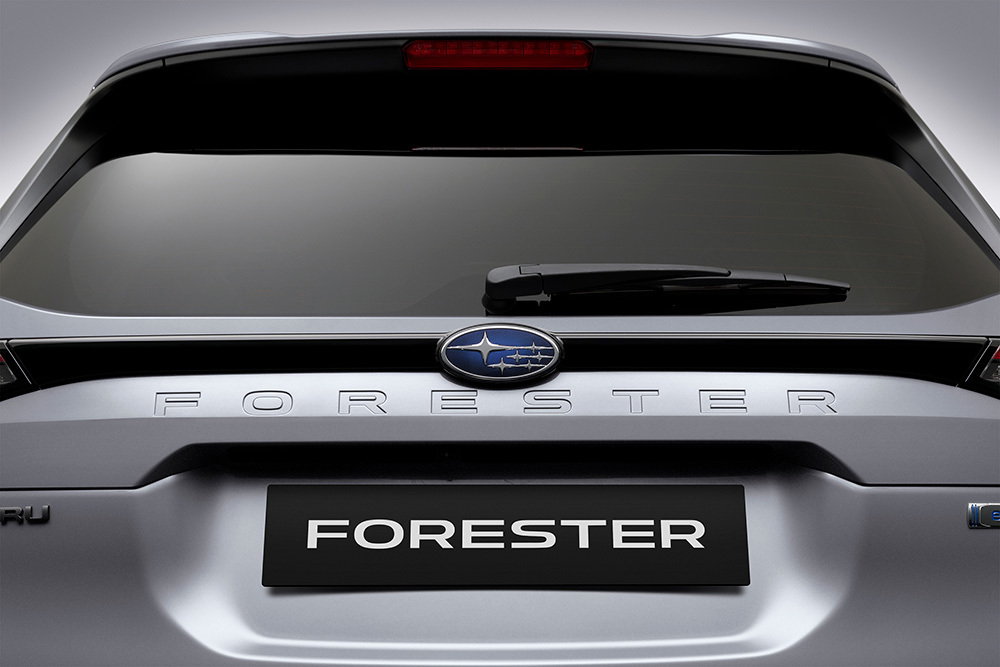 Närbild på Subaru-emblemet och den inpräntade Forester-logotypen på bilens baklucka.