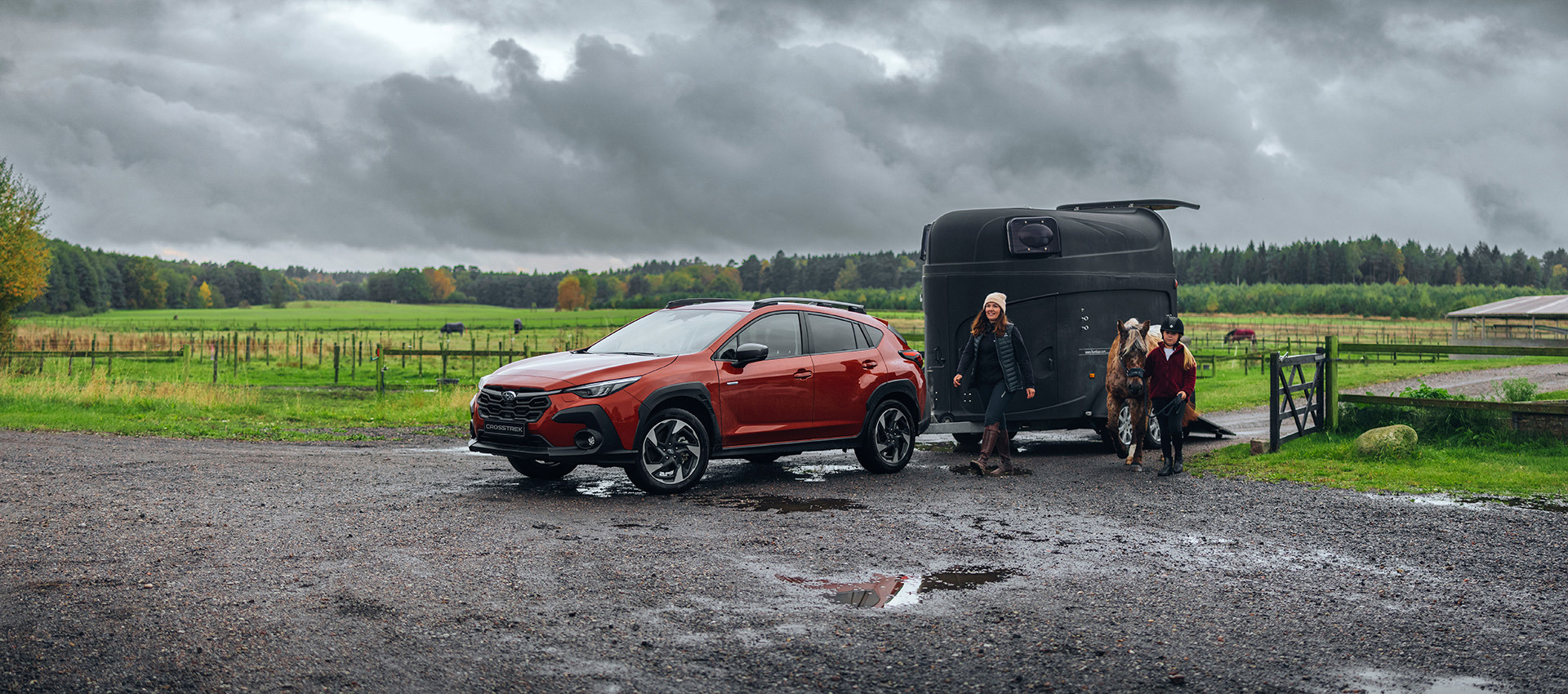 Subaru Crosstrek med hästtrailer i lerig terräng – visar på bilens robusta framkomlighet och pålitlighet för aktiva familjer med hästintresse.