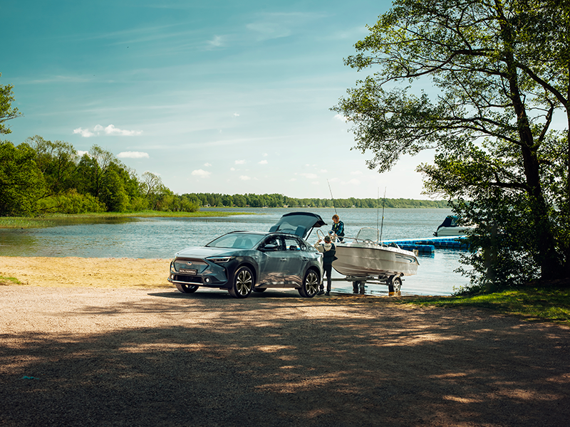 Subaru Solterra på stranden med motorbåt på trailer – elbil med dragkraft för dig som lever nära hav, natur och frihet.