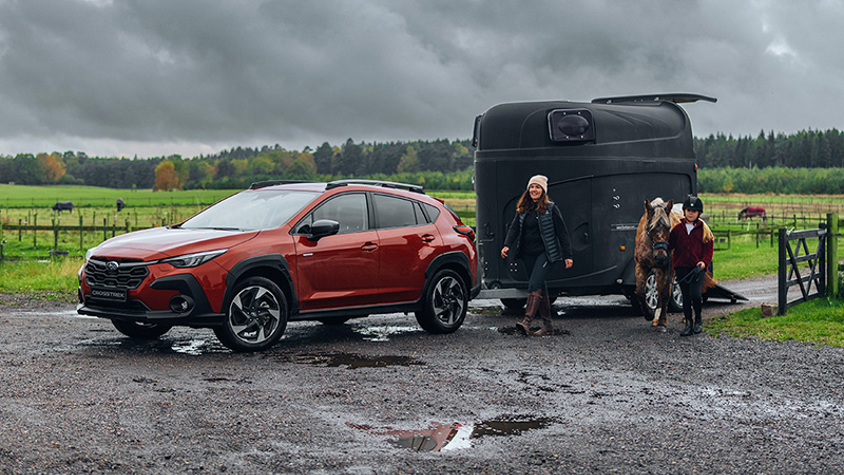 Subaru Crosstrek i lerig miljö med hästsläp – perfekt för hästägare och aktiva familjer, med fyrhjulsdrift, dragstyrka och trygghet i alla väglag.